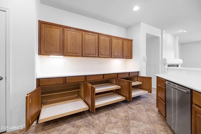 kitchen with brown cabinets, stainless steel dishwasher, recessed lighting, light countertops, and light tile patterned floors