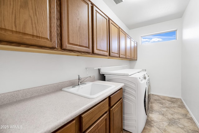 laundry area featuring washing machine and clothes dryer, visible vents, baseboards, cabinet space, and a sink