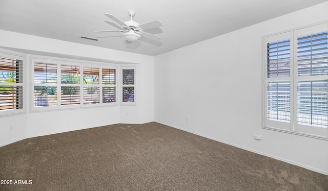 unfurnished room with baseboards, visible vents, carpet floors, and ceiling fan