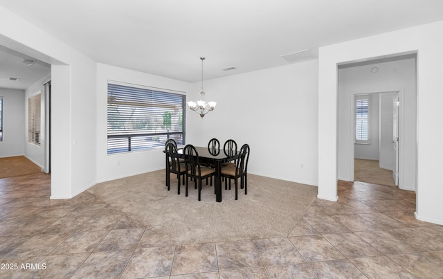 dining space with baseboards, visible vents, carpet floors, tile patterned floors, and a chandelier