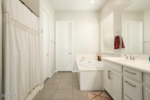 bathroom with tile patterned flooring, a tub, and vanity