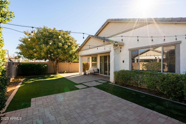 back of house with a patio area and a lawn