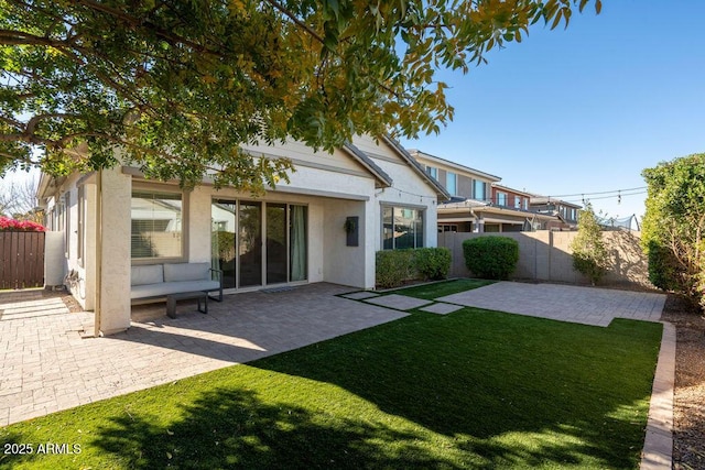 back of house featuring a lawn and a patio area