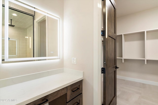 bathroom with a shower, vanity, and tile patterned floors