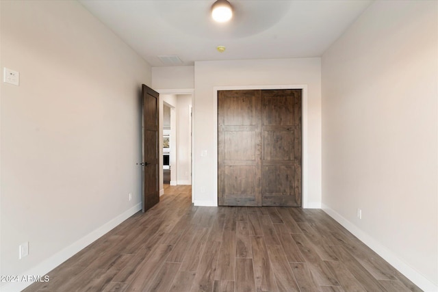 unfurnished bedroom featuring wood-type flooring and a closet