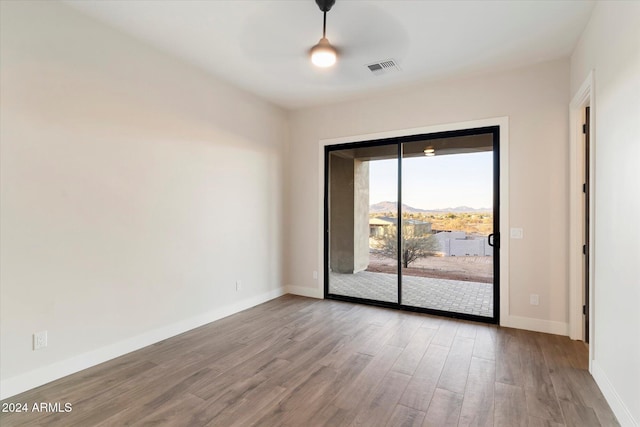 unfurnished room with a mountain view and wood-type flooring