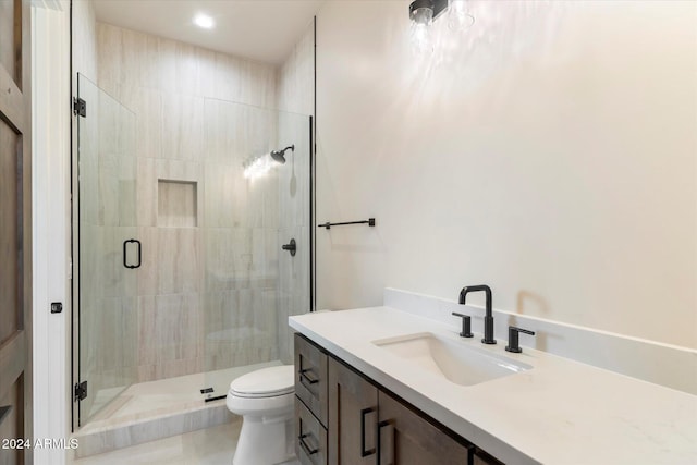 bathroom featuring tile patterned flooring, vanity, toilet, and a shower with shower door