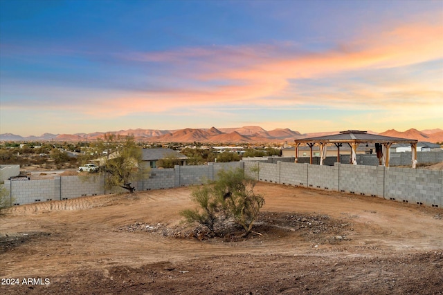 yard at dusk with a gazebo and a mountain view