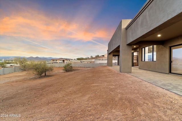 yard at dusk with a mountain view and a patio area