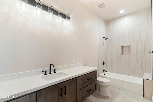 full bathroom featuring tile patterned floors, vanity, tiled shower / bath combo, and toilet