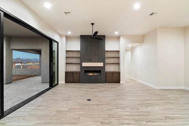 unfurnished living room featuring light hardwood / wood-style flooring and a tiled fireplace