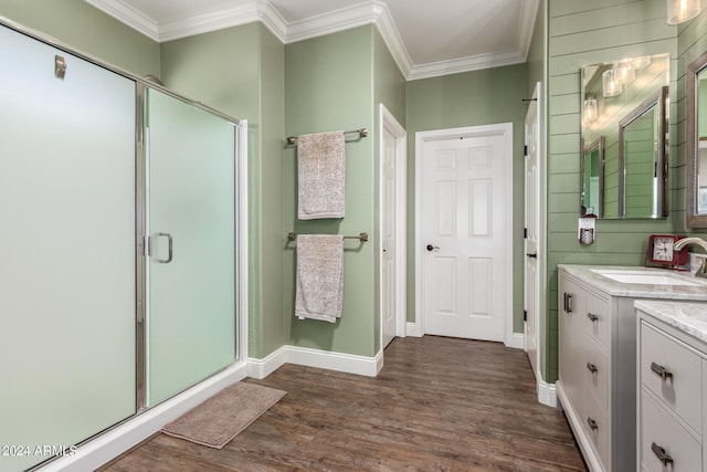 bathroom with vanity, crown molding, wood-type flooring, and a shower with shower door