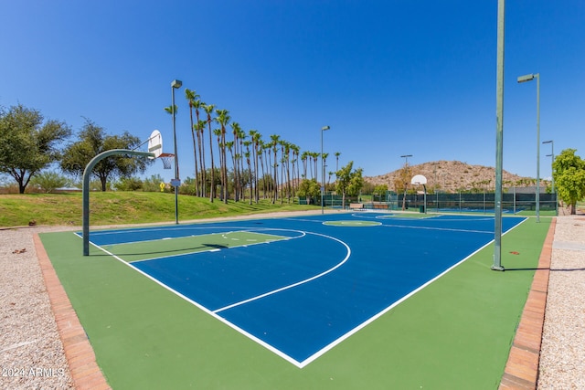 view of basketball court with a mountain view and a lawn