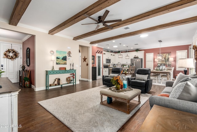 living room featuring dark wood-type flooring, ceiling fan, beam ceiling, and crown molding