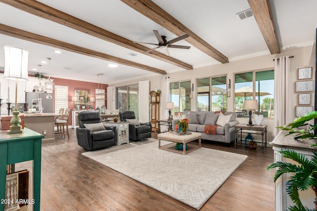 living room featuring dark wood-type flooring, ornamental molding, and beamed ceiling