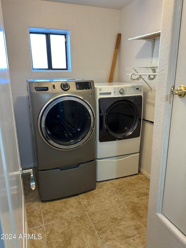 washroom featuring independent washer and dryer and light tile patterned flooring