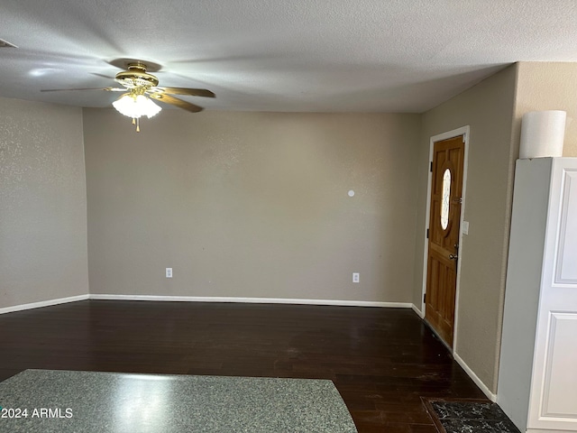 unfurnished room with dark hardwood / wood-style flooring, a textured ceiling, and ceiling fan