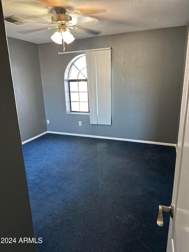 empty room featuring ceiling fan and a textured ceiling