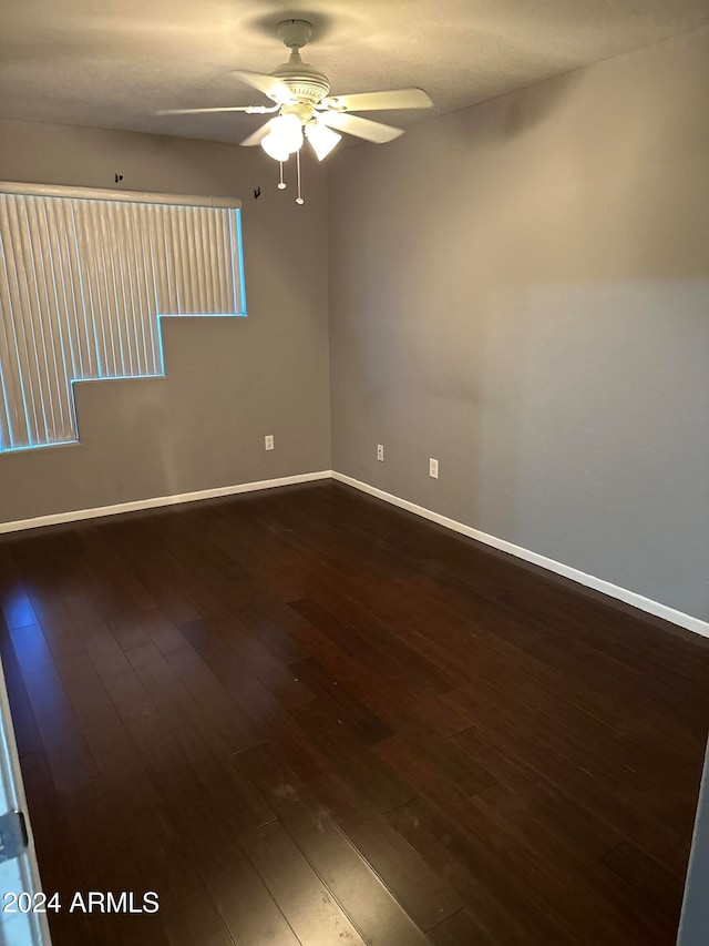 unfurnished room with dark wood-type flooring and ceiling fan