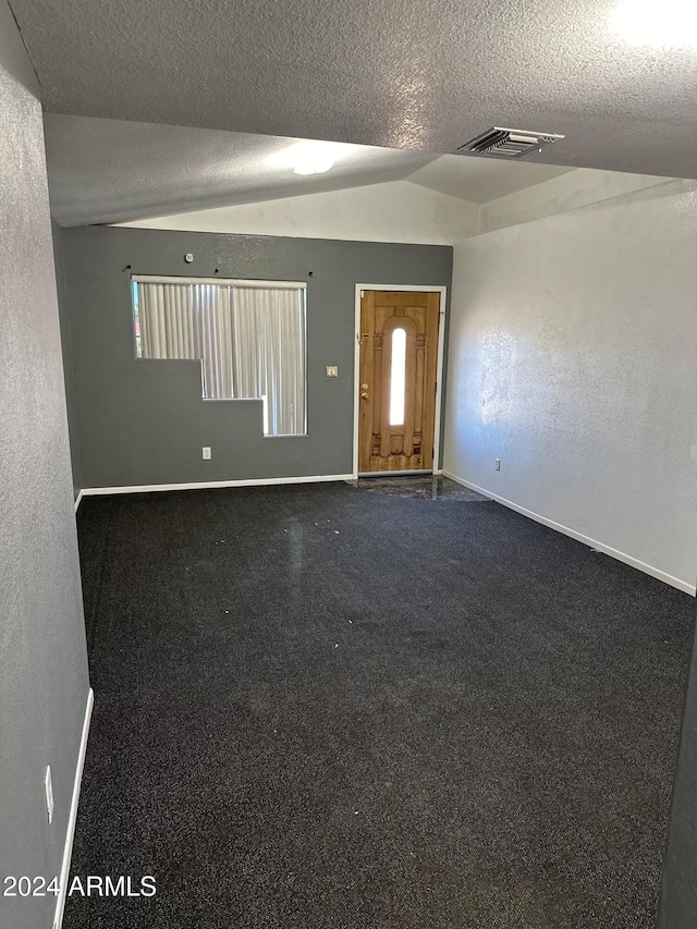 empty room featuring lofted ceiling and a textured ceiling