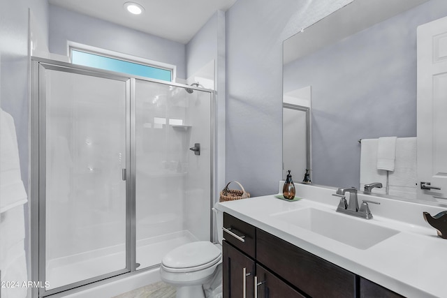 bathroom with vanity, an enclosed shower, and toilet