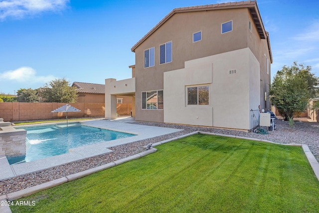 view of pool with a lawn and a patio