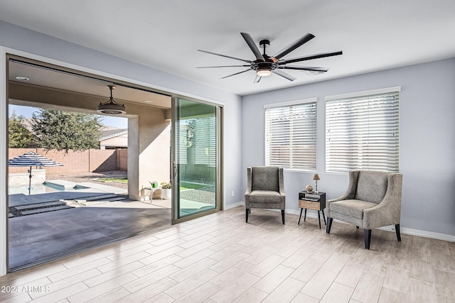 living area featuring ceiling fan and light wood-type flooring