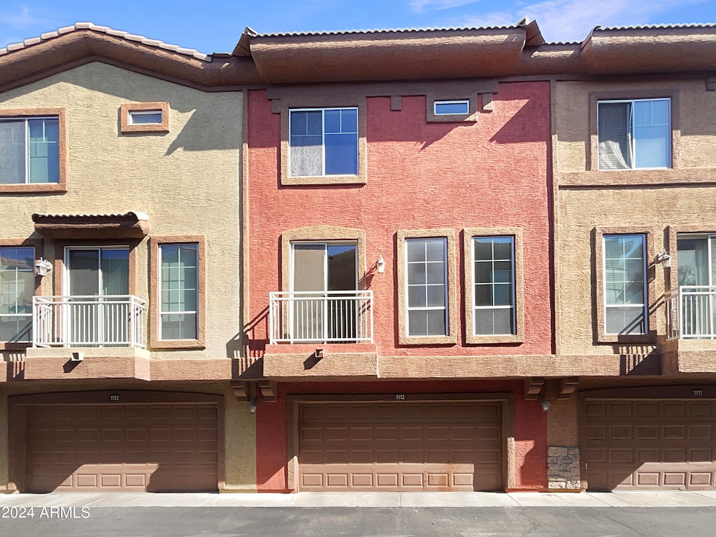 multi unit property featuring a balcony and a garage