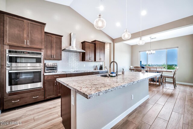 kitchen featuring pendant lighting, a healthy amount of sunlight, sink, and tasteful backsplash