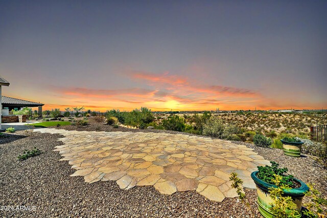 patio terrace at dusk with a grill and exterior kitchen