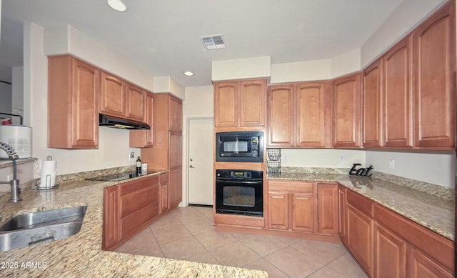 1851 W Vermont Ave, Phoenix, AZ 85015 - kitchen with black appliances, under cabinet range hood, light stone counters, a sink, and light tile patterned floors