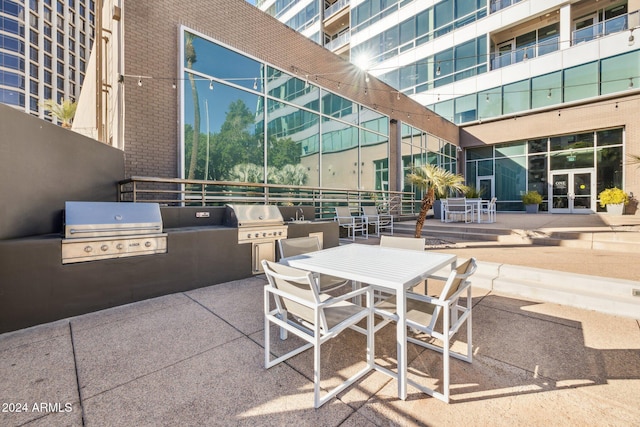 view of patio / terrace featuring area for grilling, an outdoor kitchen, french doors, and outdoor dining area
