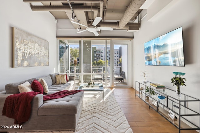 living area featuring a ceiling fan and a towering ceiling