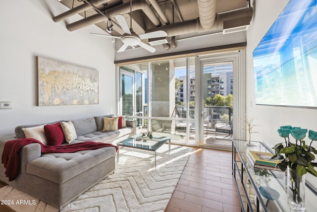 living area with tile patterned flooring and ceiling fan