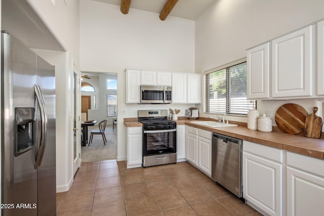 13680 E Paradise Dr, Scottsdale, AZ 85259 - kitchen with a high ceiling, appliances with stainless steel finishes, light tile patterned flooring, a sink, and beam ceiling