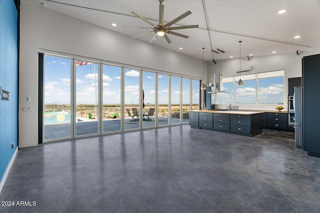 interior space with a high ceiling, concrete flooring, baseboards, ceiling fan, and recessed lighting