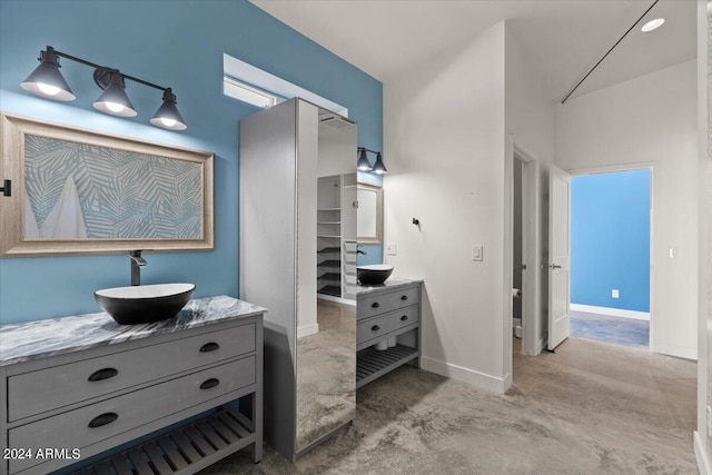 full bathroom featuring baseboards, vanity, and concrete flooring