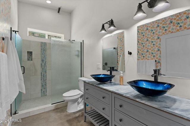 bathroom featuring a stall shower, double vanity, toilet, and a sink
