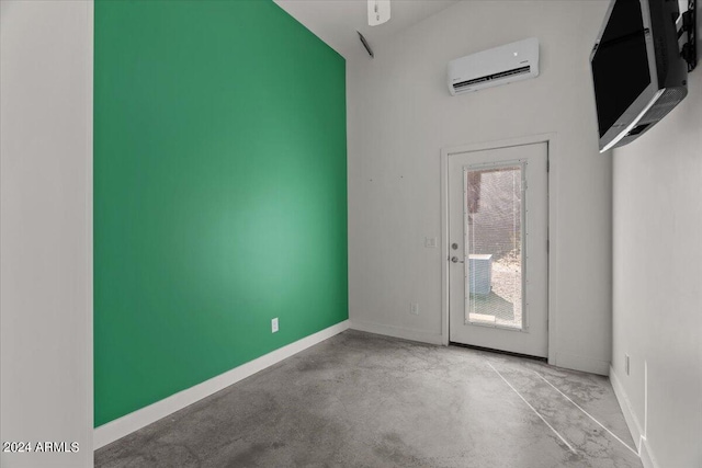 interior space with baseboards, concrete flooring, and an AC wall unit