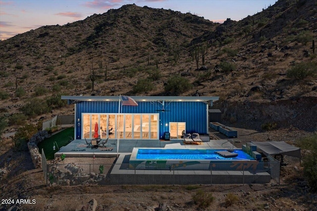 pool with a patio area, fence, and a mountain view