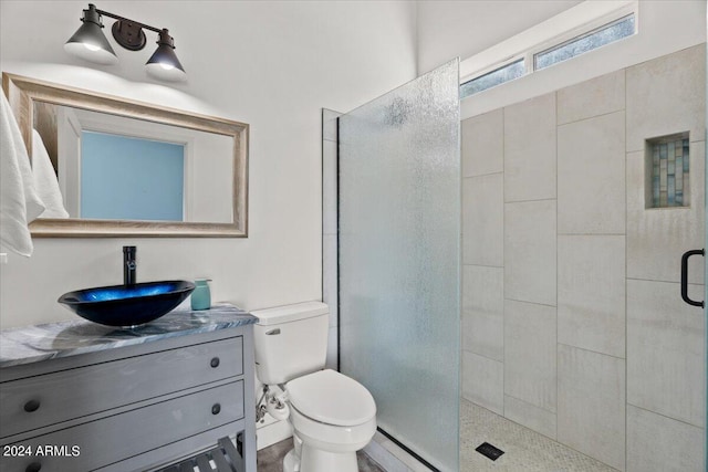 bathroom with vanity, baseboard heating, a shower with shower door, and toilet