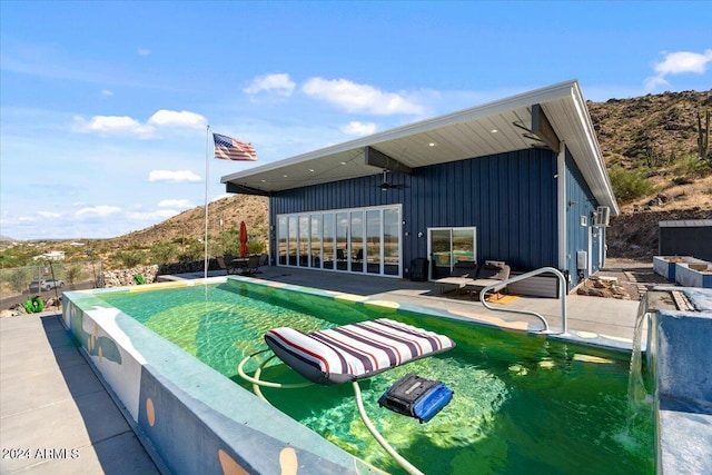view of pool with an infinity pool, fence, and a patio