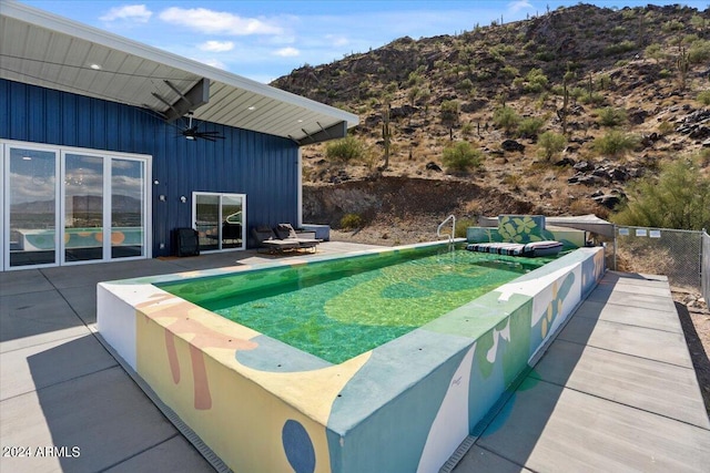 view of swimming pool with a mountain view and a patio