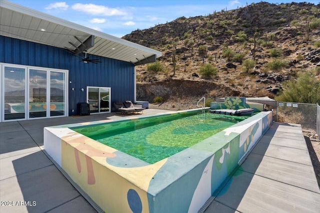 view of swimming pool featuring ceiling fan and a patio area