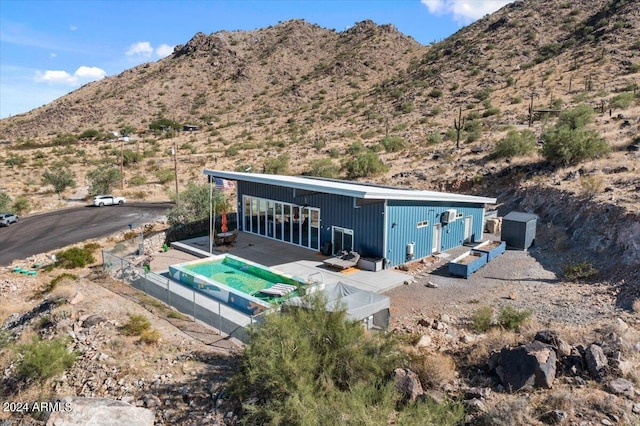 exterior space featuring a mountain view, fence, and a patio area