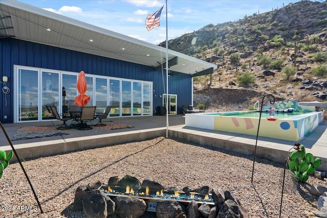 back of property featuring a mountain view and a patio