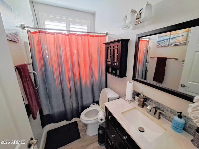 bathroom with toilet, vanity, and hardwood / wood-style flooring