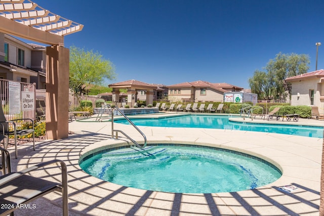 view of swimming pool with a patio, a hot tub, and a pergola