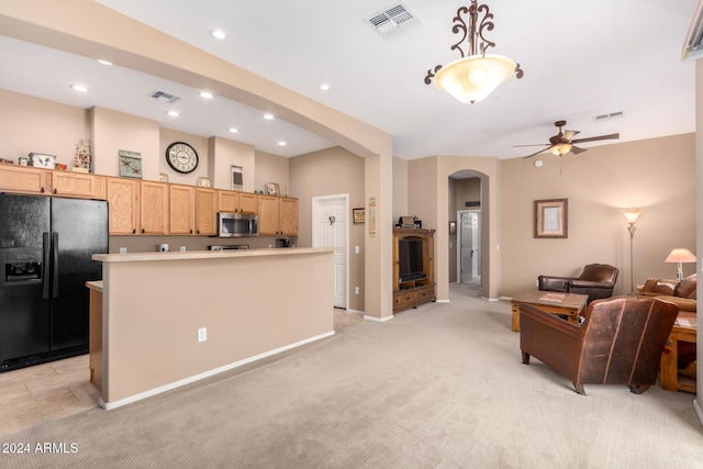 kitchen with light carpet, black refrigerator with ice dispenser, ceiling fan, decorative light fixtures, and a center island