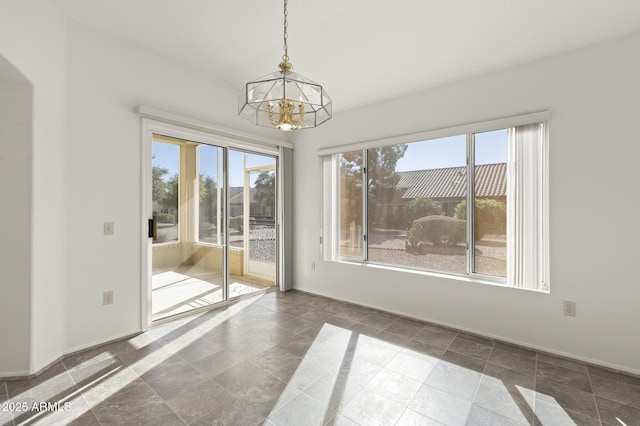 spare room featuring a healthy amount of sunlight and an inviting chandelier